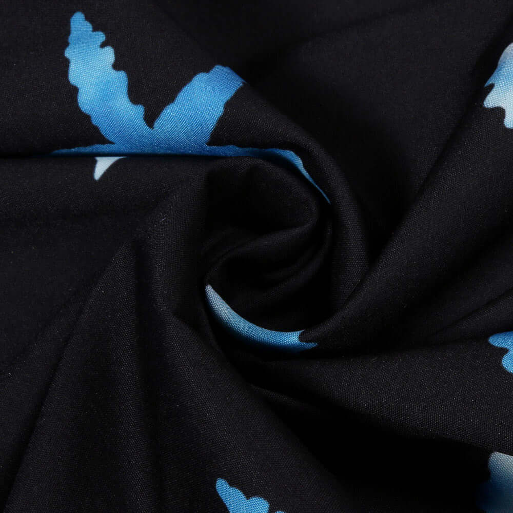 Close-up of a black fabric with blue leaf patterns, showcasing texture and design detail.